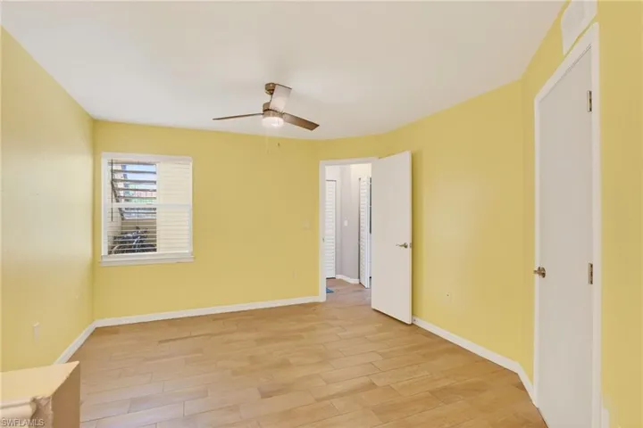 Kitchen with wainscoting, suspended lighting, stainless steel appliances, white cabinets, and light wood finished floors