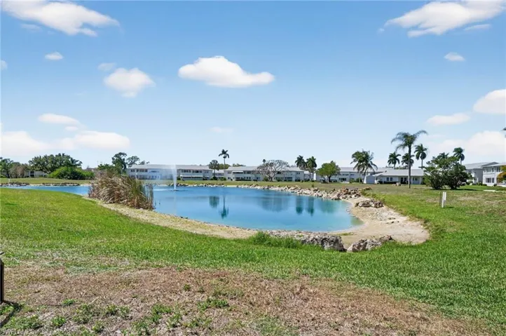 View of apartment building / complex featuring stairs and covered and uncovered parking