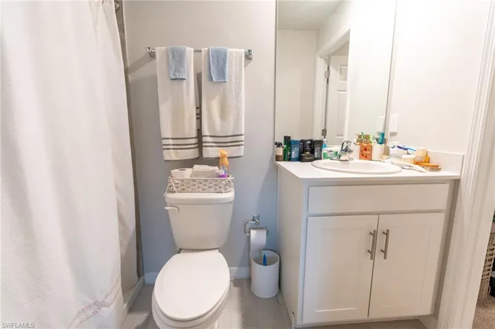 Bathroom featuring vanity, toilet, and a shower with shower curtain