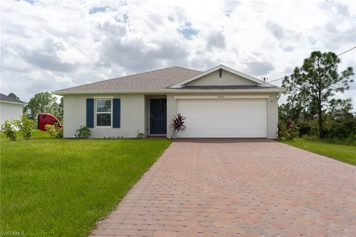 Single story home featuring a garage and a front lawn