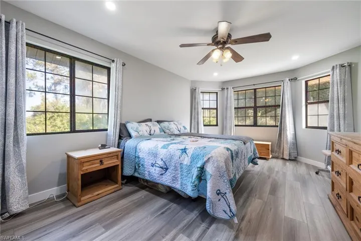 Bedroom with wood finished floors, recessed lighting, baseboards, and ceiling fan