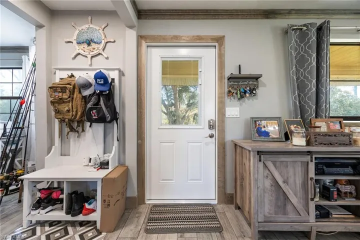 Mudroom with light wood finished floors and crown molding