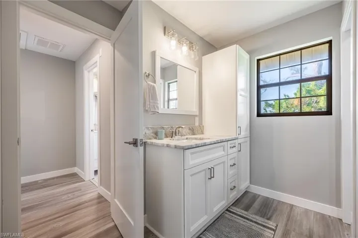 Bathroom with wood finished floors, baseboards, and vanity