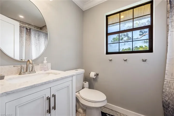 Bathroom featuring crown molding, toilet, vanity, and baseboards