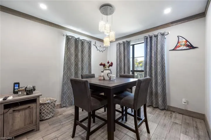 Dining room with ornamental molding, a chandelier, light wood finished floors, baseboards, and recessed lighting