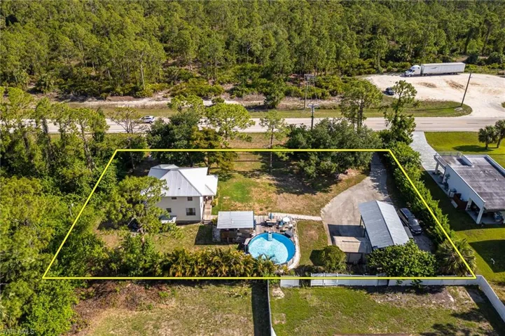 Aerial overview of property's location featuring property boundaries highlighted, a heavily wooded area, and a pool