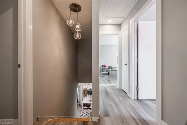 Hallway with wood finished floors and attic access