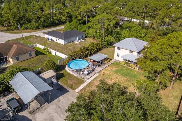 Aerial view of property and surrounding area featuring a heavily wooded area