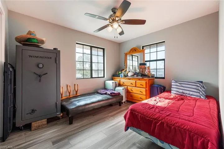 Bedroom featuring wood finished floors, radiator heating unit, and ceiling fan
