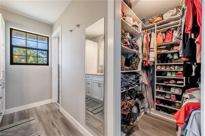 Walk in closet with light wood-style flooring