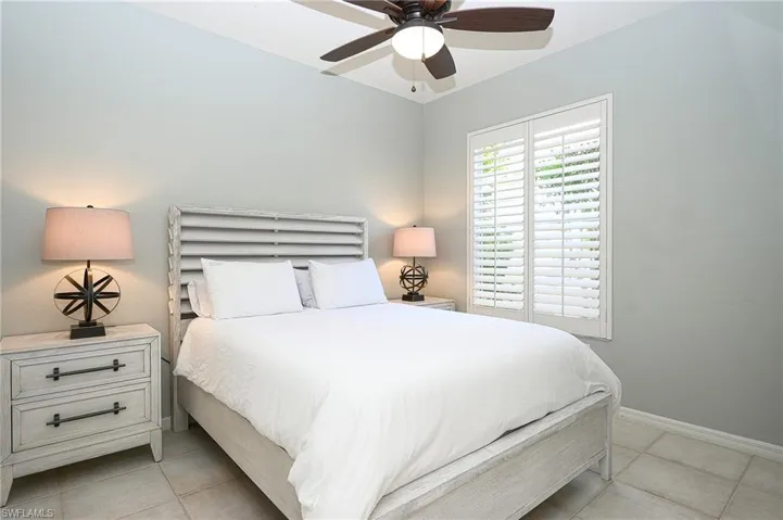 Tiled bedroom featuring ceiling fan
