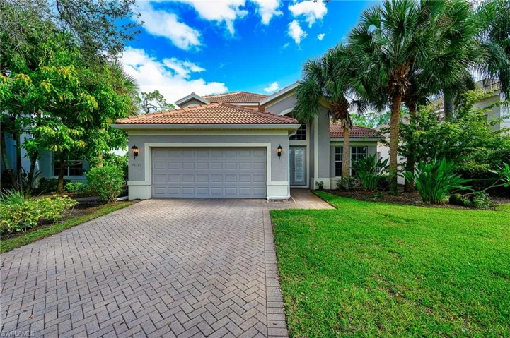 View of front of property featuring a garage and a front yard