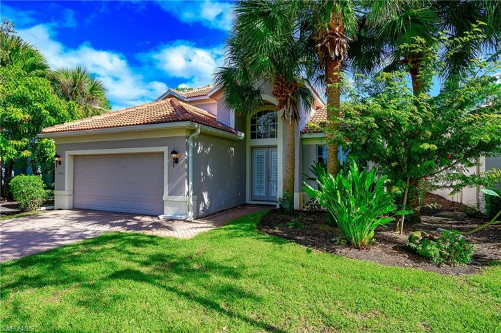Mediterranean / spanish-style house featuring a garage and a front lawn