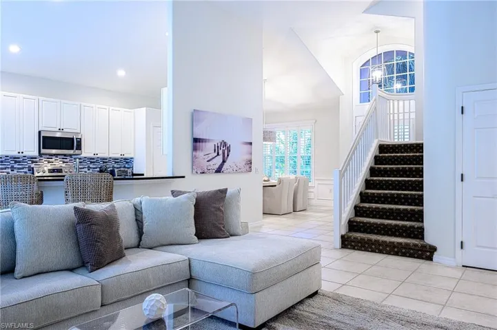 Living room with high vaulted ceiling, a chandelier, and light tile patterned floors