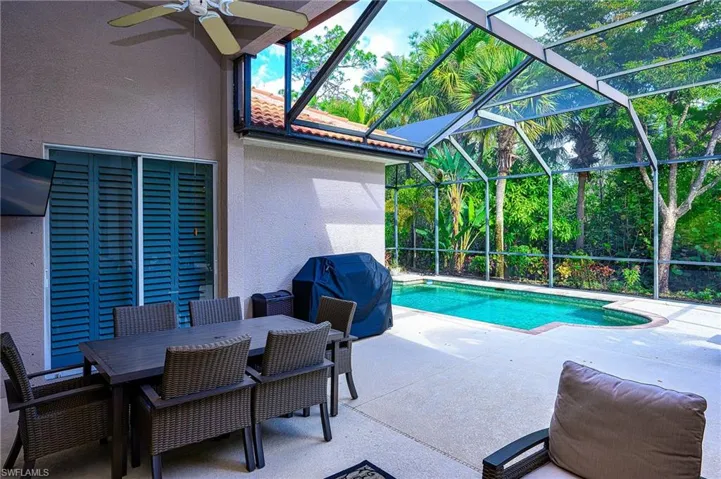 View of swimming pool with a patio area, a grill, a lanai, and ceiling fan