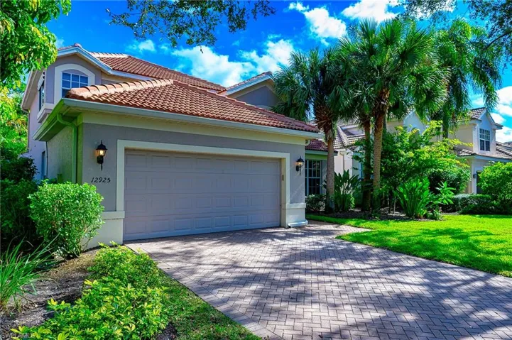 Mediterranean / spanish house with a garage and a front lawn