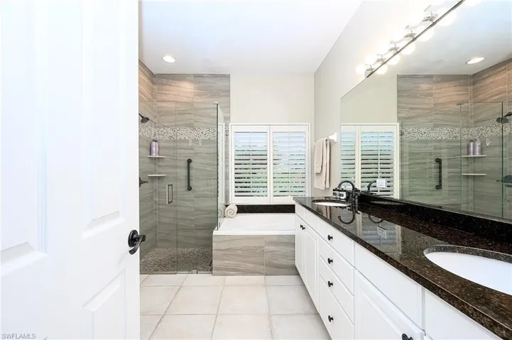 Bathroom featuring vanity, tile patterned flooring, and shower with separate bathtub