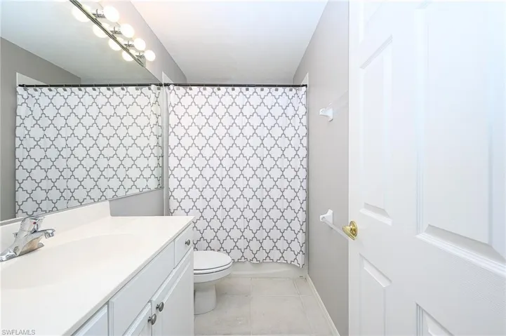 Bathroom featuring vanity, tile patterned floors, and toilet