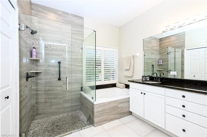 Bathroom with vanity, tile patterned floors, and separate shower and tub