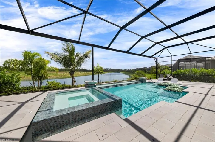 View of swimming pool featuring an in ground hot tub, a patio area, and a lanai