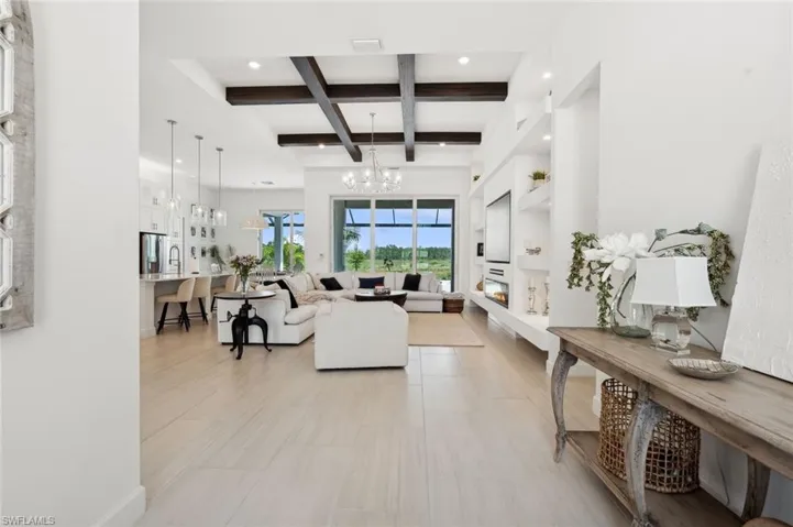 Living room featuring beam ceiling, a notable chandelier, and coffered ceiling
