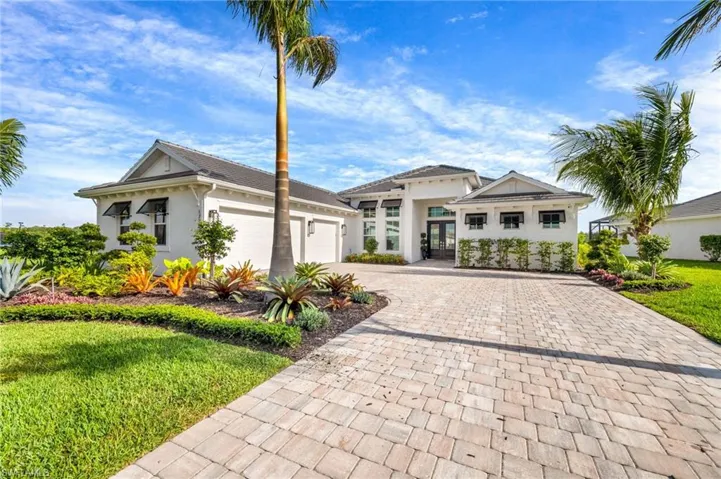 View of front of house with a garage and a front yard with upgraded landscaping