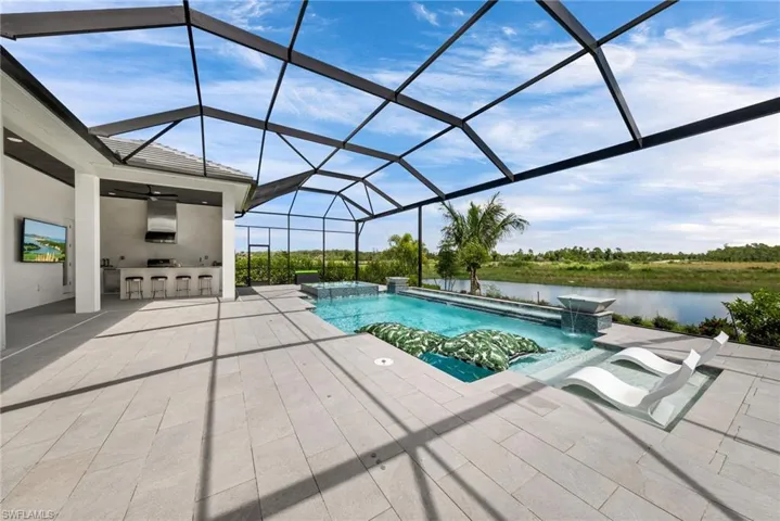 View of pool featuring pool water feature, glass enclosure, a jacuzzi, and a patio area