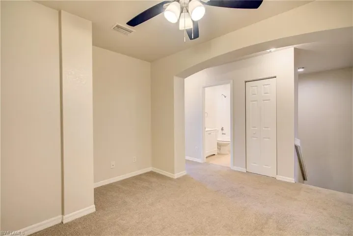 Spare room featuring light colored carpet and ceiling fan