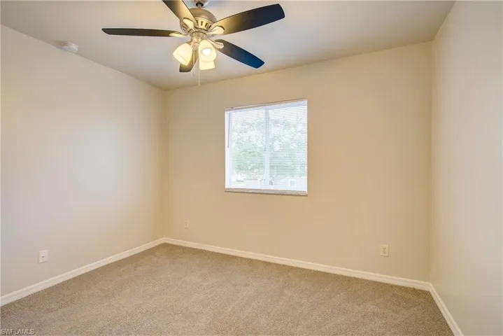 Carpeted empty room with ceiling fan