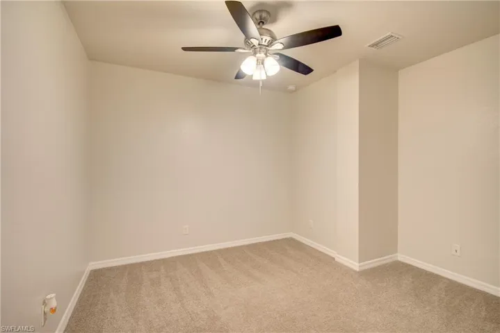 Unfurnished room with ceiling fan and light carpet