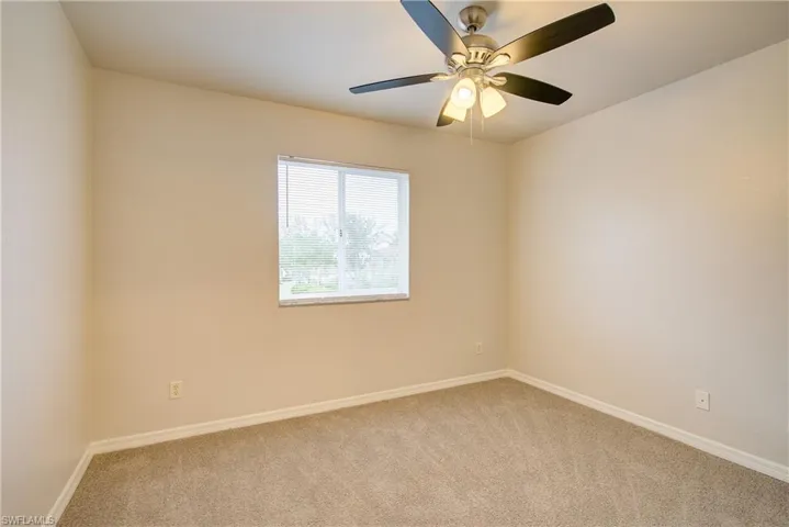 Spare room featuring ceiling fan and light colored carpet