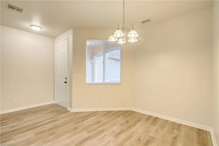 Empty room featuring a chandelier and light wood-type flooring