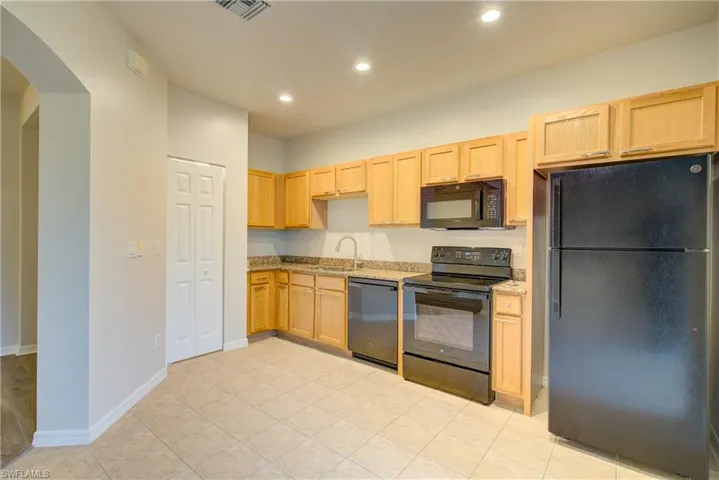 Kitchen featuring sink, black appliances, and light brown cabinets