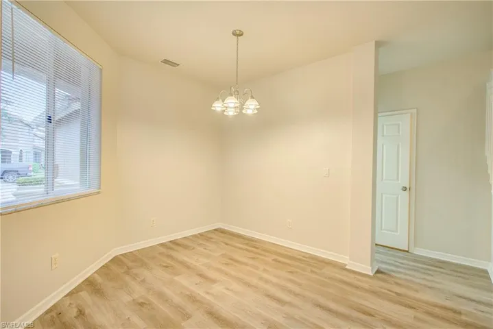 Spare room with a chandelier and light hardwood / wood-style floors