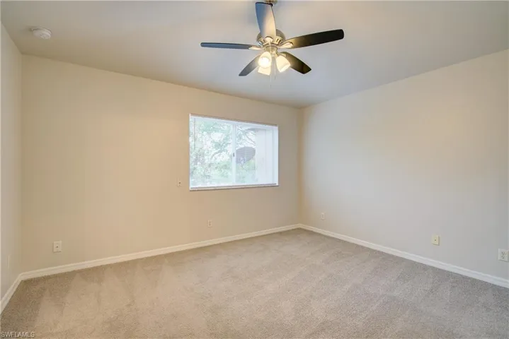 Carpeted spare room with ceiling fan
