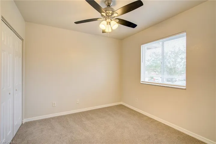 Unfurnished bedroom featuring light carpet, a closet, and ceiling fan