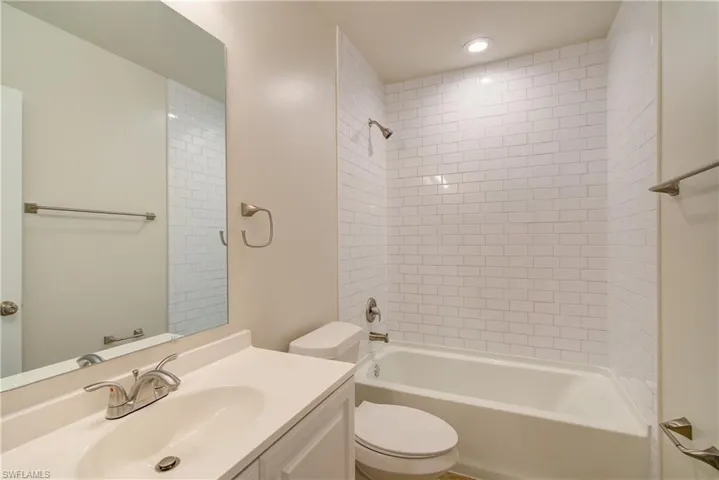 Full bathroom featuring vanity, toilet, and tiled shower / bath combo