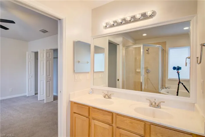 Bathroom featuring ceiling fan, vanity, and independent shower and bath