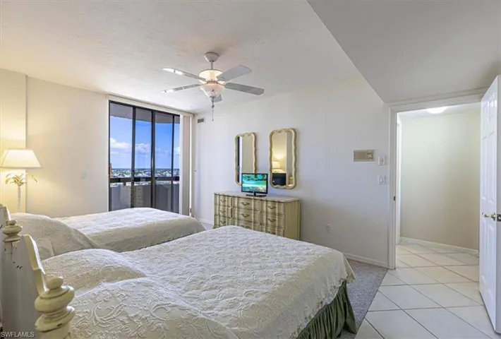 Bedroom with access to exterior, a textured ceiling, light tile patterned floors, ceiling fan, and floor to ceiling windows
