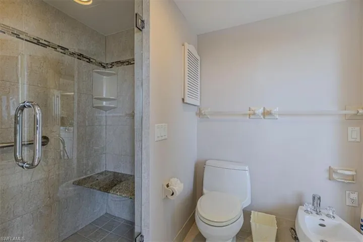Bathroom with a shower stall and a bidet