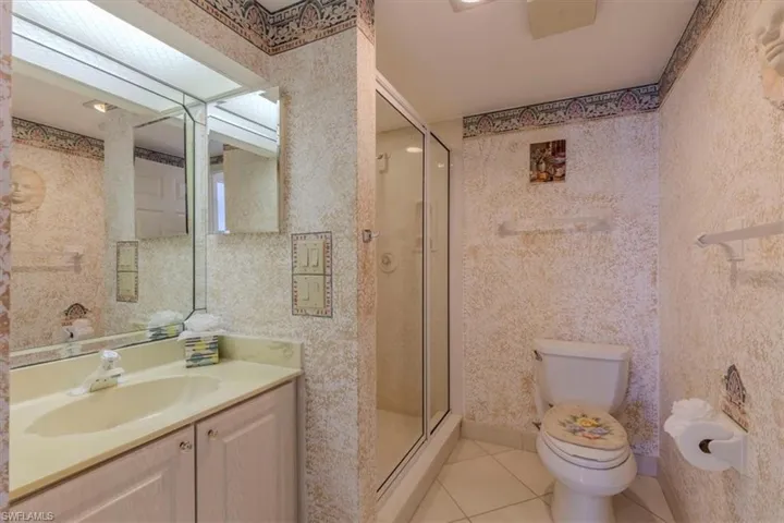 Bathroom featuring vanity, light tile patterned flooring, and a shower stall