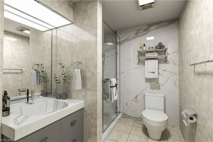 Bathroom with tile walls, vanity, light tile patterned floors, and a marble finish shower