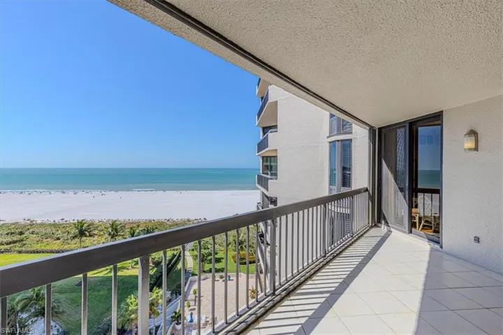 Balcony featuring view of water and beach