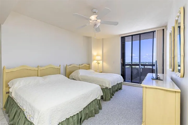 Bedroom with access to outside, light colored carpet, and a ceiling fan