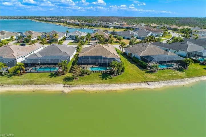 Aerial perspective of suburban area featuring a nearby body of water