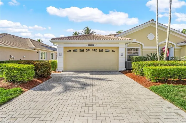 View of front facade featuring decorative driveway, stucco siding, a garage, and a tile roof