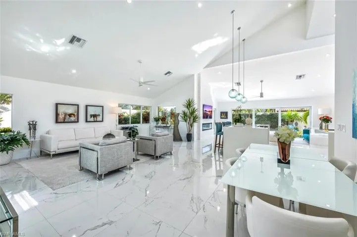 Living room with ceiling fan and high vaulted ceiling