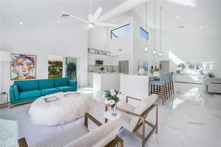Living room featuring ceiling fan and a towering ceiling