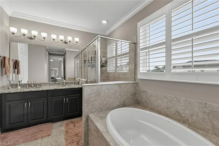 Spacious bathroom featuring a dual vanity with a granite countertop, undermount sinks, and a large mirror