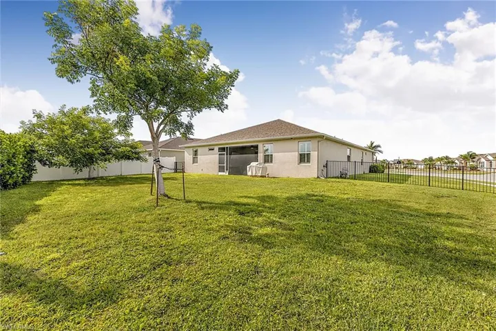 Expansive green lawn with a mature tree